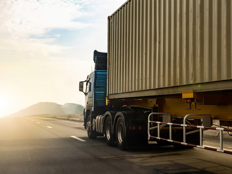 A container truck on the highway at sunrise