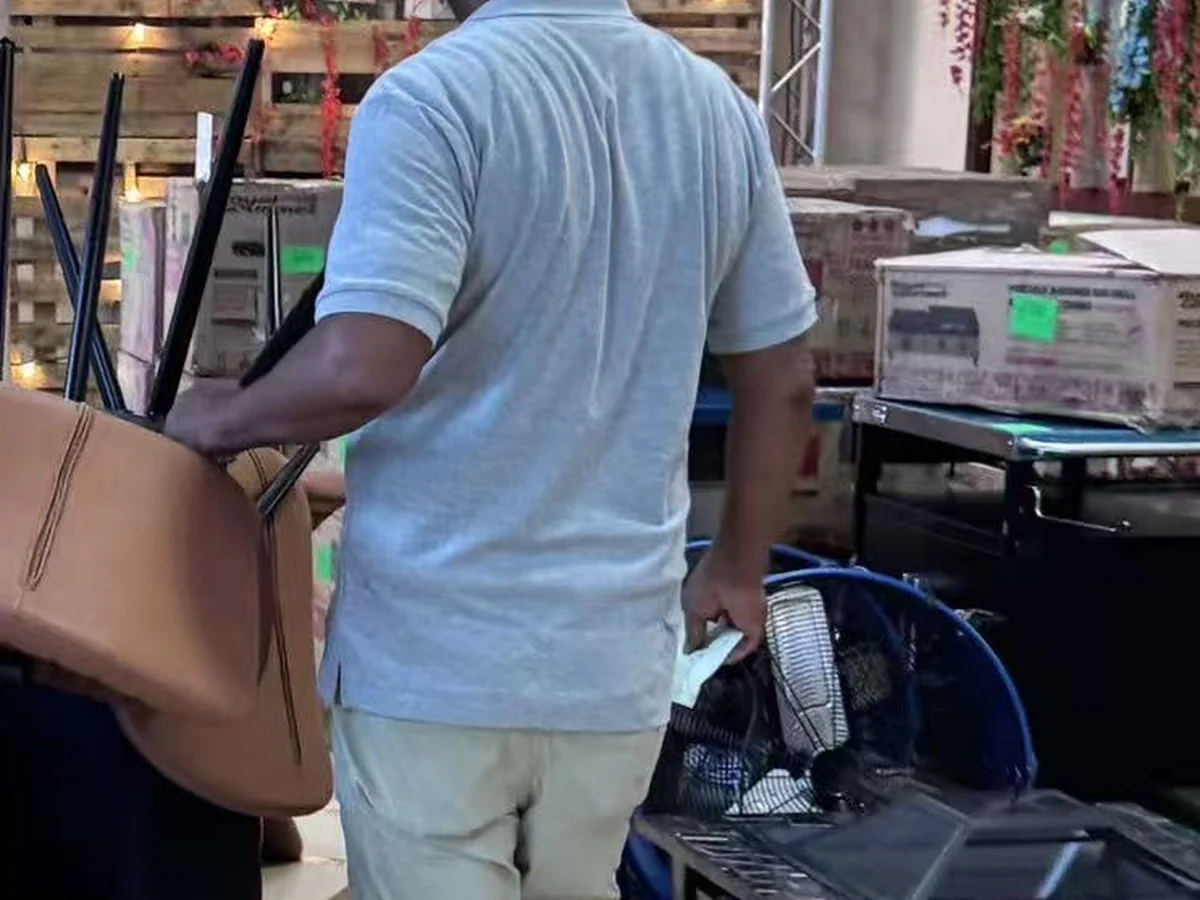 A buyer wheeling an accent chair and a side table out of the Cube-Age Houston sale floor on a pallet