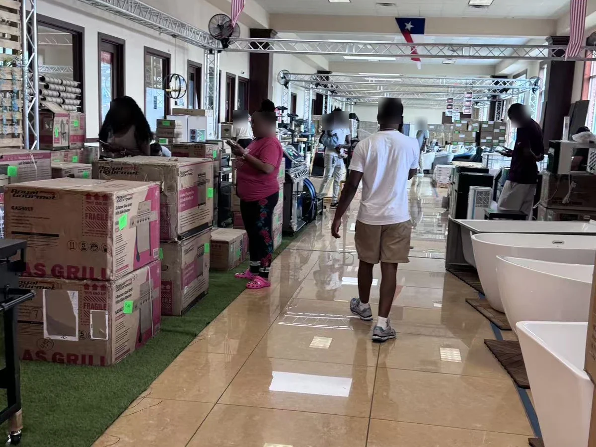 The main aisle on day one, gas grills boxed and tagged on the left, freestanding tubs on the right