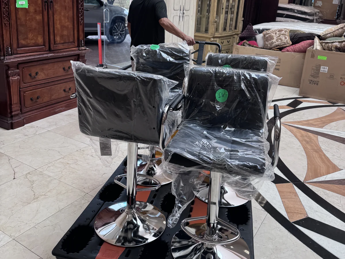 Wrapped bar stools stacked on a pallet cart on the Cube-Age Houston sale floor