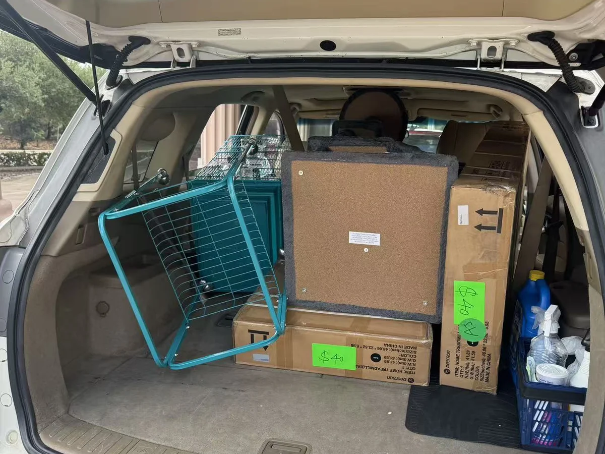 An SUV loaded with boxed goods and a wire cart outside the Cube-Age Houston sale
