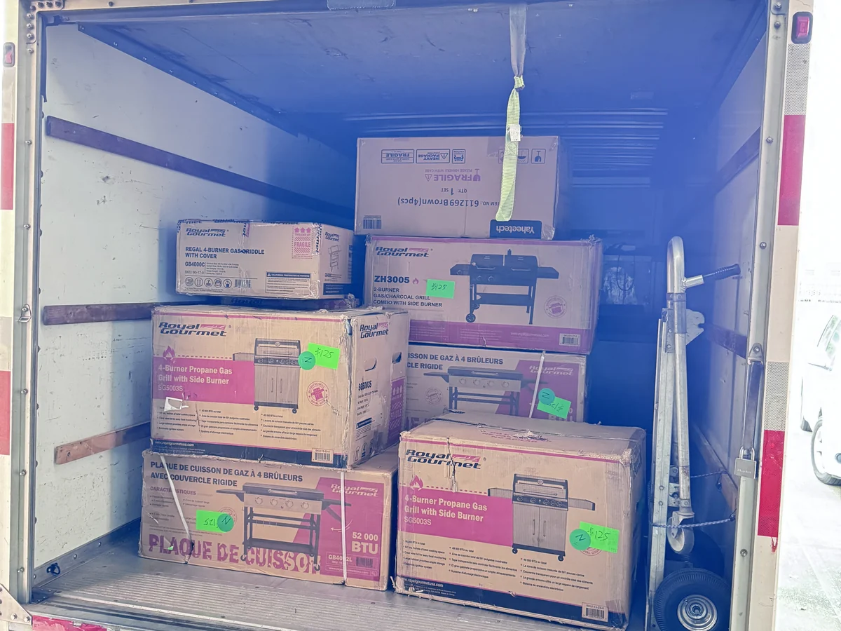 A wholesale buyer box truck full of sold, price-tagged gas grills and griddles from the Cube-Age Houston sale