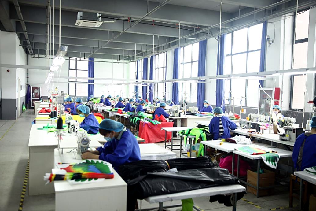 Wide view of the kite factory floor with the full production line running