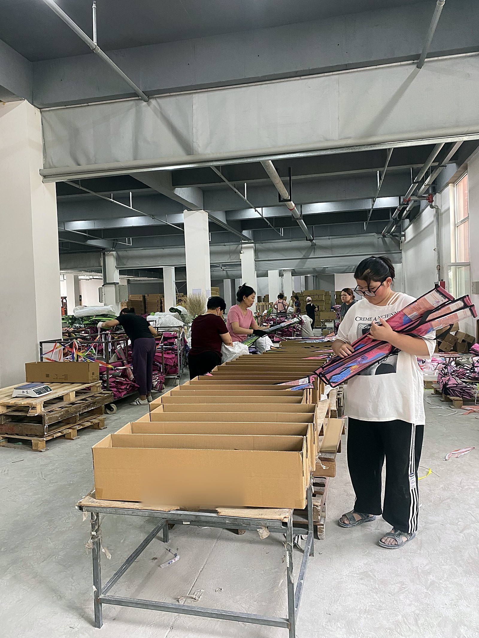 Finished kites packed into export cartons at the factory, stacked ready for loading
