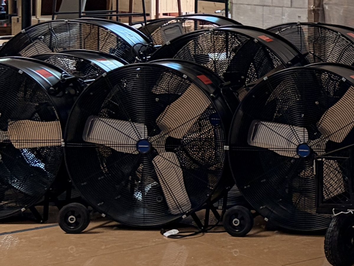 A row of industrial drum fans in our Houston warehouse