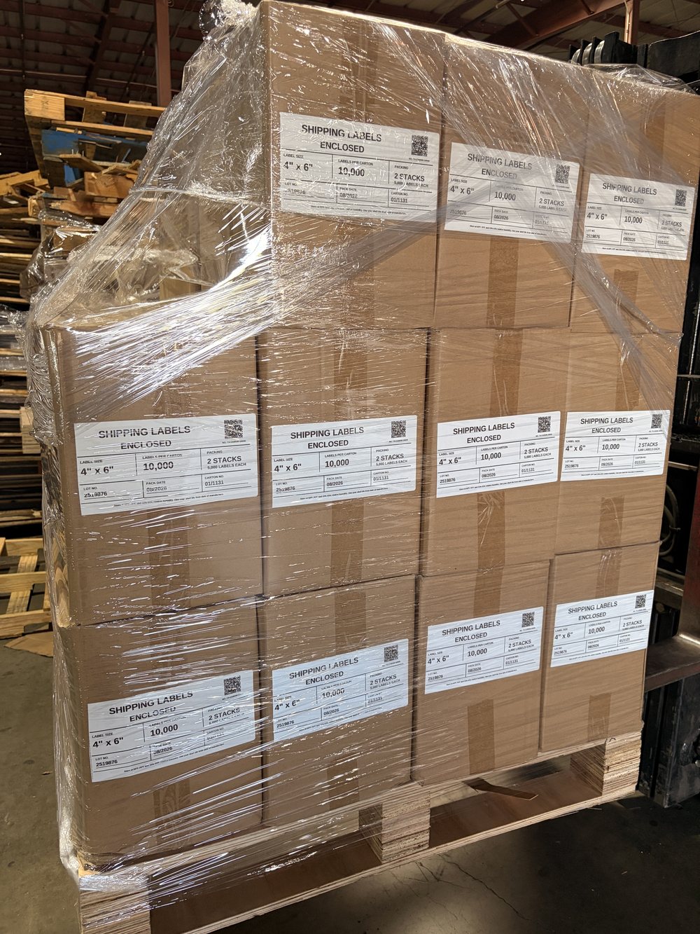 A stretch-wrapped pallet stacked with Bright Labels 4x6 shipping-label cartons, every carton face showing its packing label with lot and carton numbers, in the Cube-Age Houston warehouse