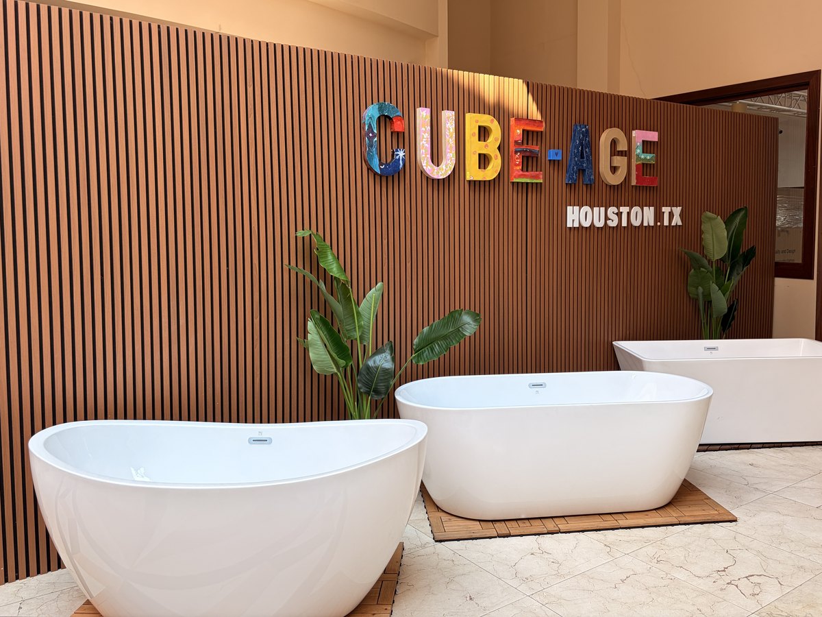 Freestanding bathtubs displayed in front of the slatted brand wall at the Cube-Age showroom