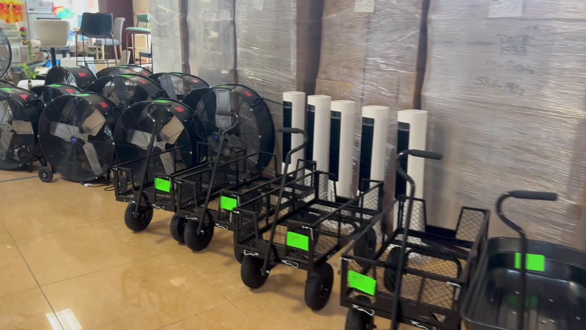Drum fans and garden carts lined up on the warehouse floor