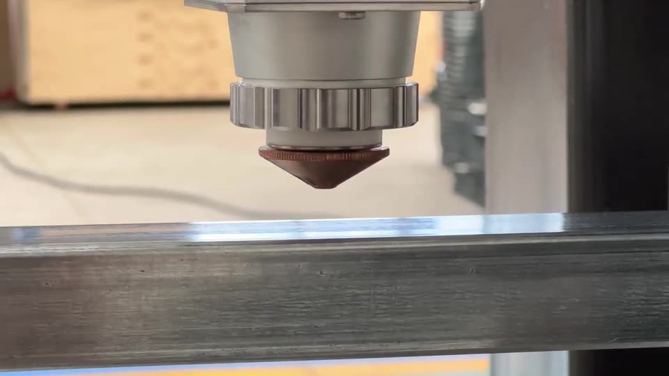 Laser head cutting a steel fence rail